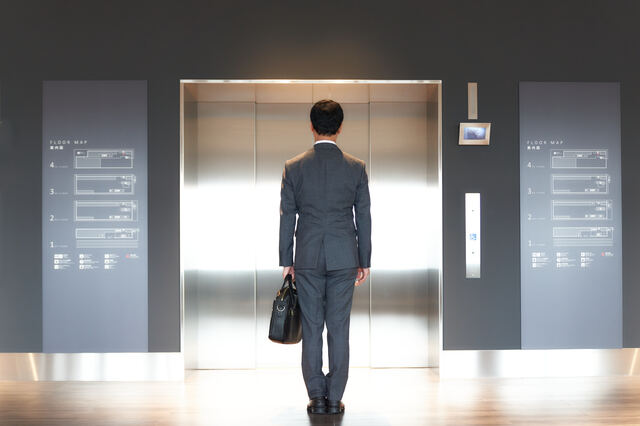エレベーターの前に立つ男性